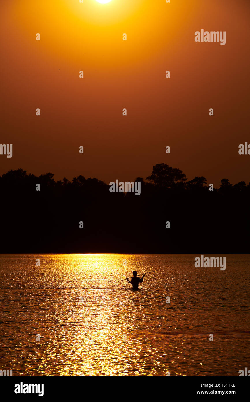 Sunset over Srah Srang with a fisherman in the lake Stock Photo
