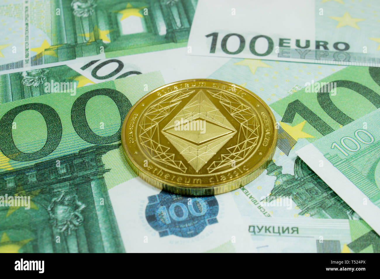 Close-up of Ethereum coins on 100 Euro banknotes. Crypto currency ETC. Stock Photo