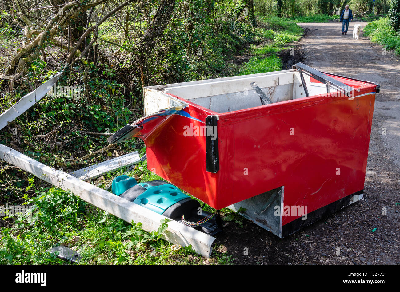 A bright red commercial freezer is dumped with other rubbish in a country lane near the village of Perton, Wolverhampton in South Staffordshire. Stock Photo