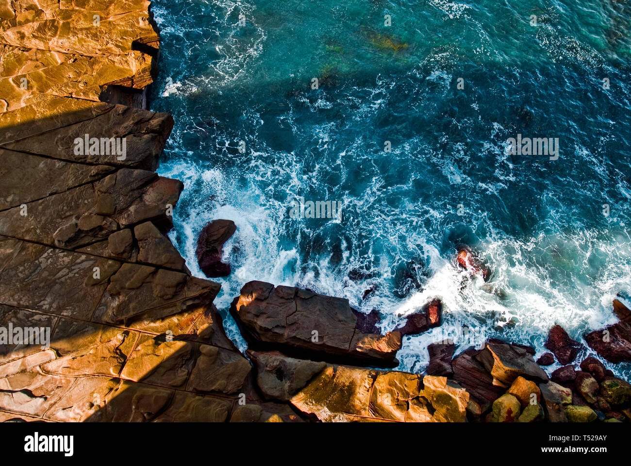 The Shadow of the Sea cliff Bridge casting a shadow on to the rocks and sea of the Illawarra Coastline, NSW, Australia Stock Photo