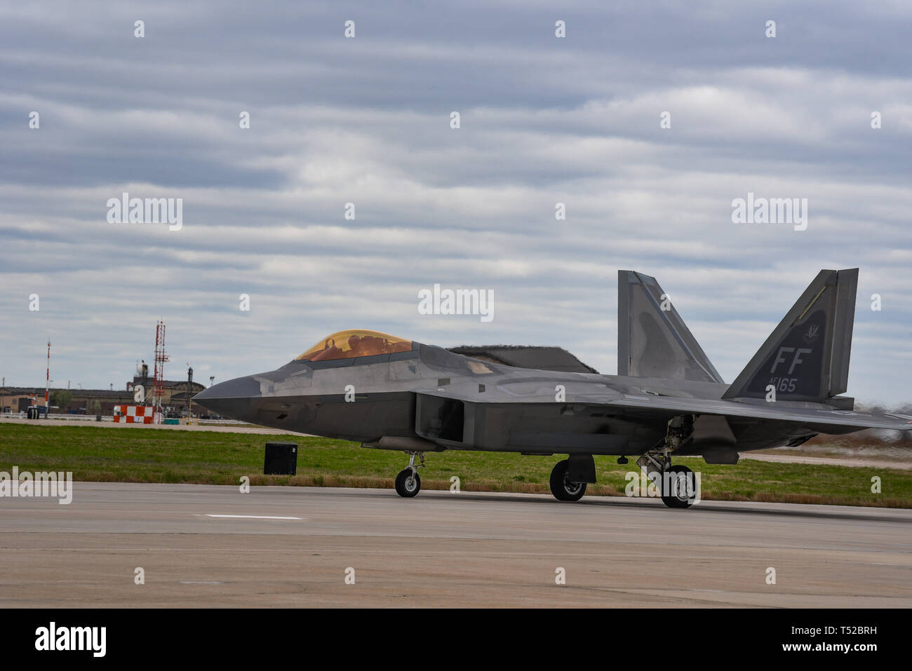 An F-22 Raptor Taxis on the flightline April 11, 2019, at McConnell Air Force Base, Kan. The increased reliability and maintainability of the F-22 will require less manpower to fix the aircraft allowing for it to operate more efficiently. (U.S. Air Force photo by Airman 1st Class Alexi Myrick) Stock Photo