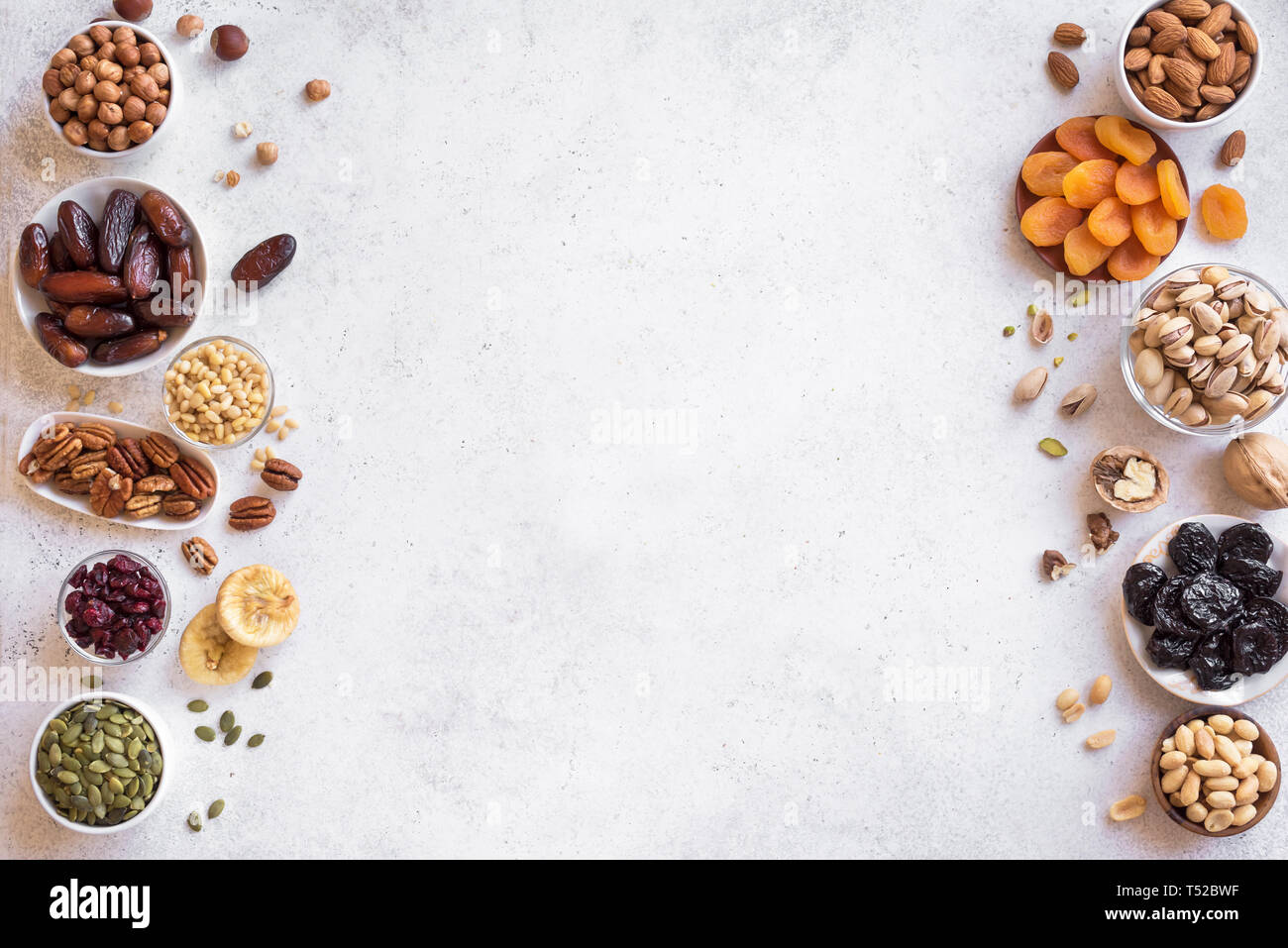 Dried fruits and Nuts in bowls on white background, top view, copy