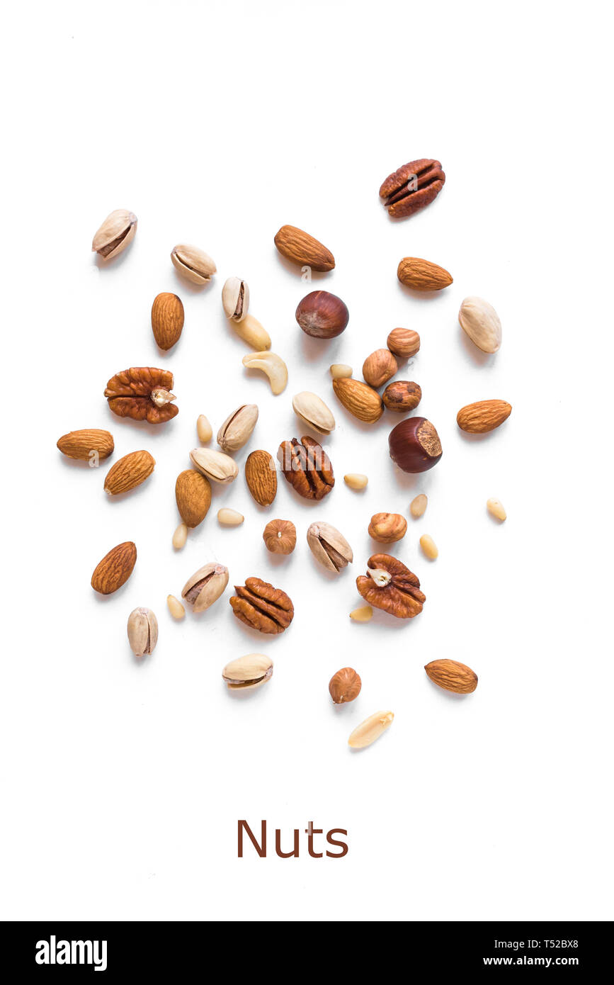 Heap of Nuts isolated on white background. Various nuts (almonds, pistachios, pecans, hazelnuts, pine nuts, peanuts). Stock Photo