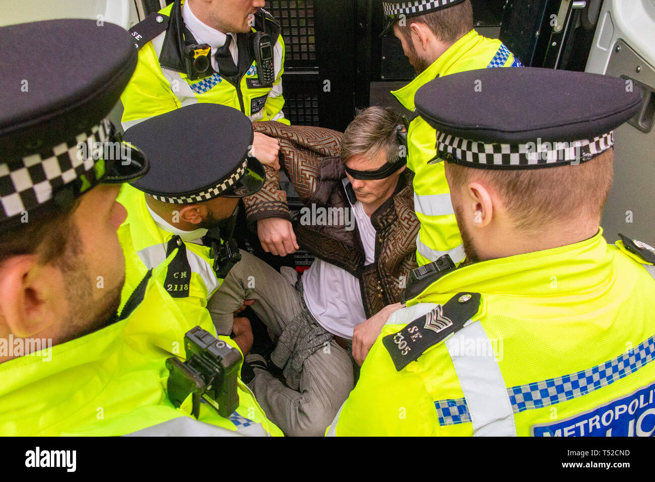 Police arrest a blindfolded environmental activist from Extinction