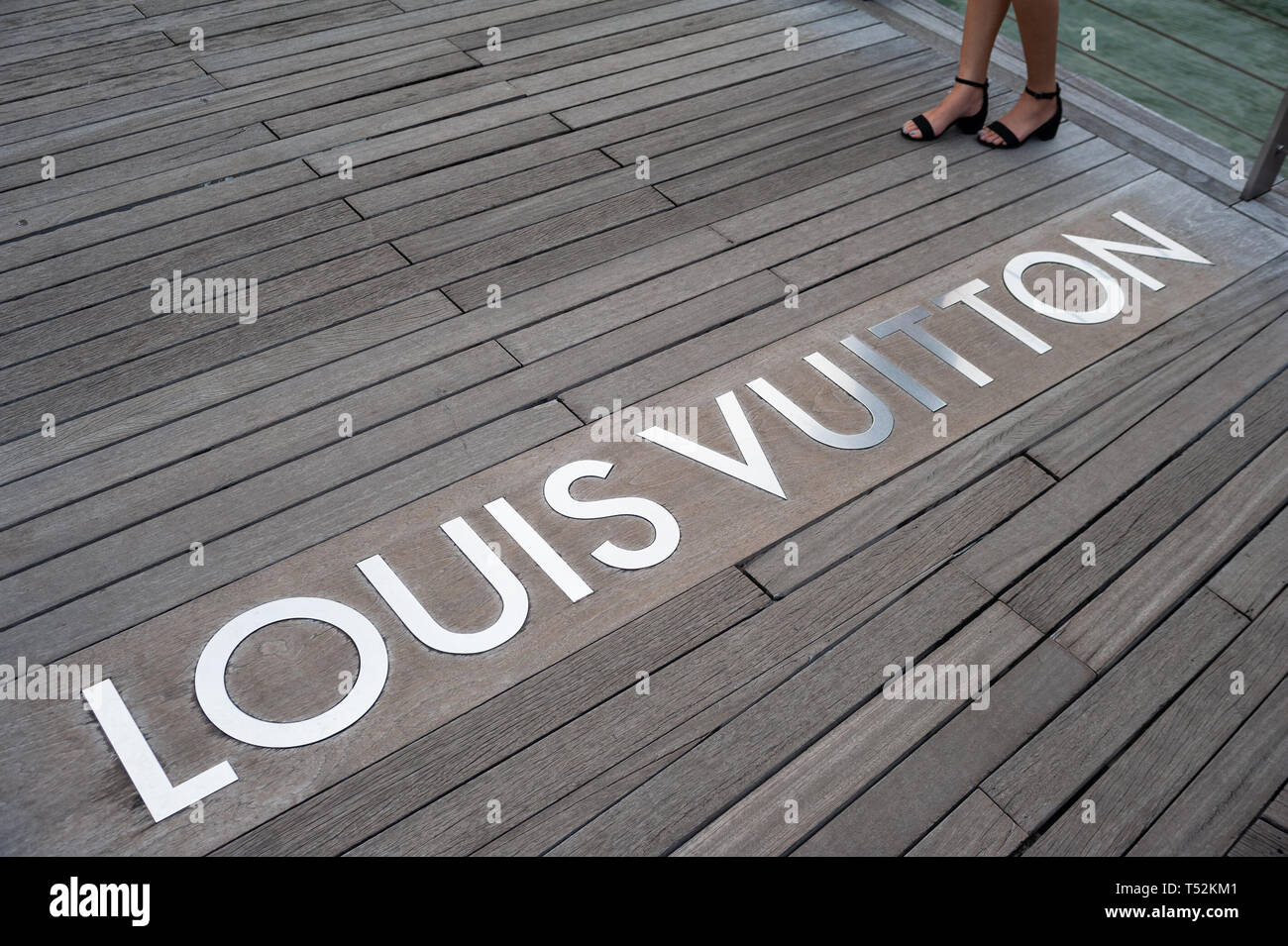 12.04.2019, Singapore, Republic of Singapore, Asia - A wooden walkway is leading to the Louis Vuitton luxury boutique at the Marina Bay Sands. Stock Photo