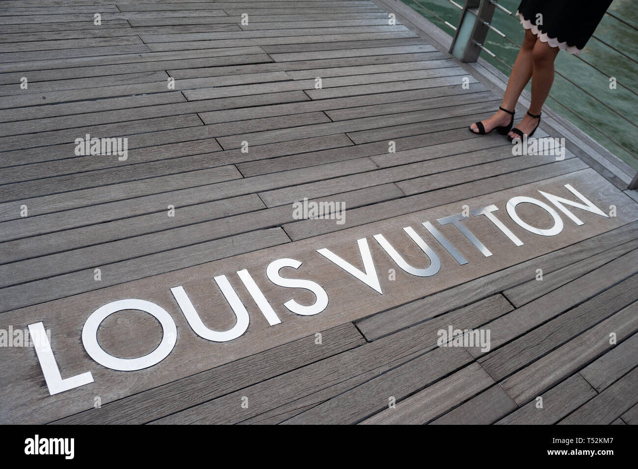 12.04.2019, Singapore, Republic of Singapore, Asia - A wooden walkway is leading to the Louis Vuitton luxury boutique at the Marina Bay Sands. Stock Photo