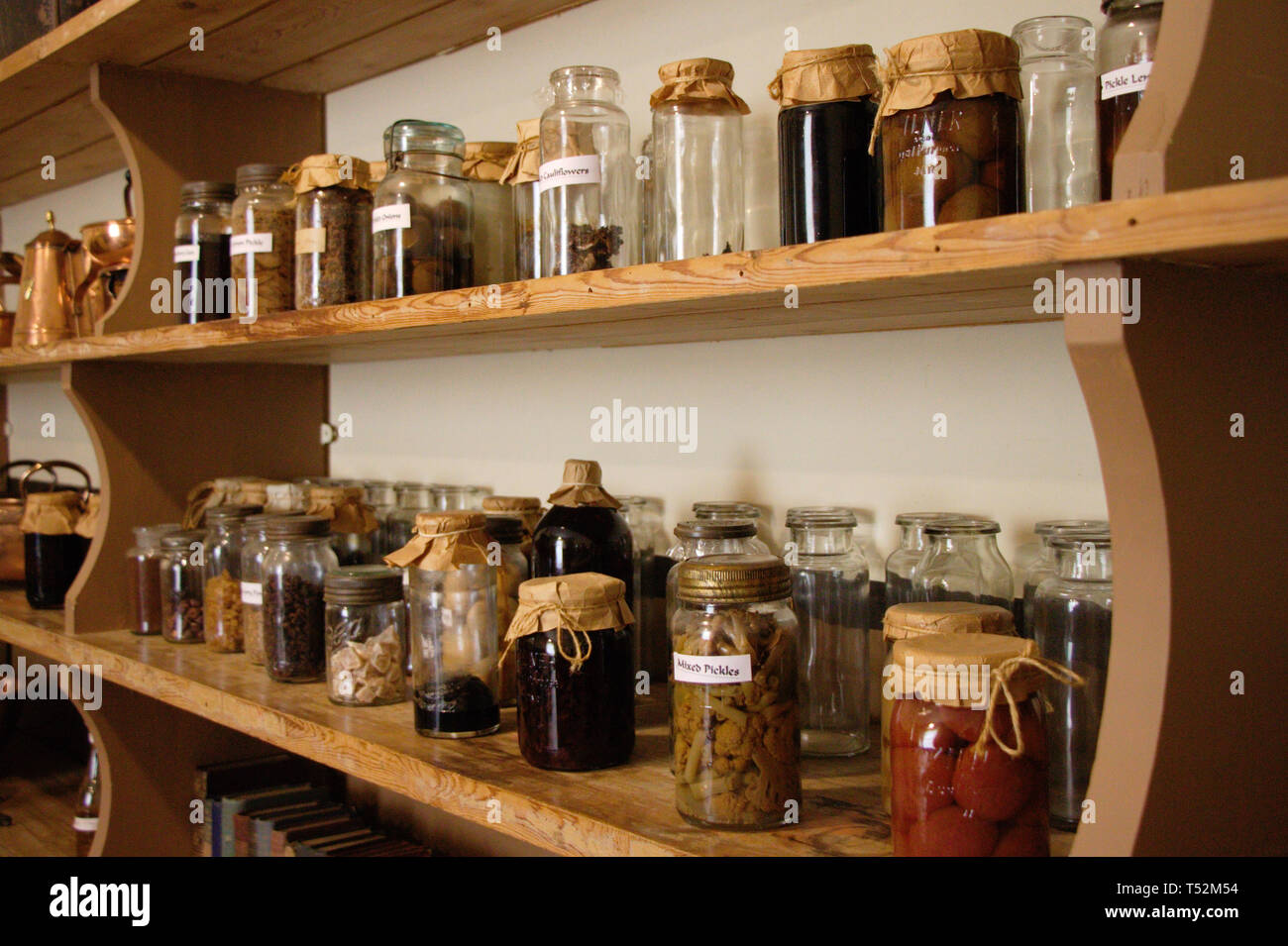 Row of jars on a shelf. Antique kitchen. Preserved food, spices. Stock Photo