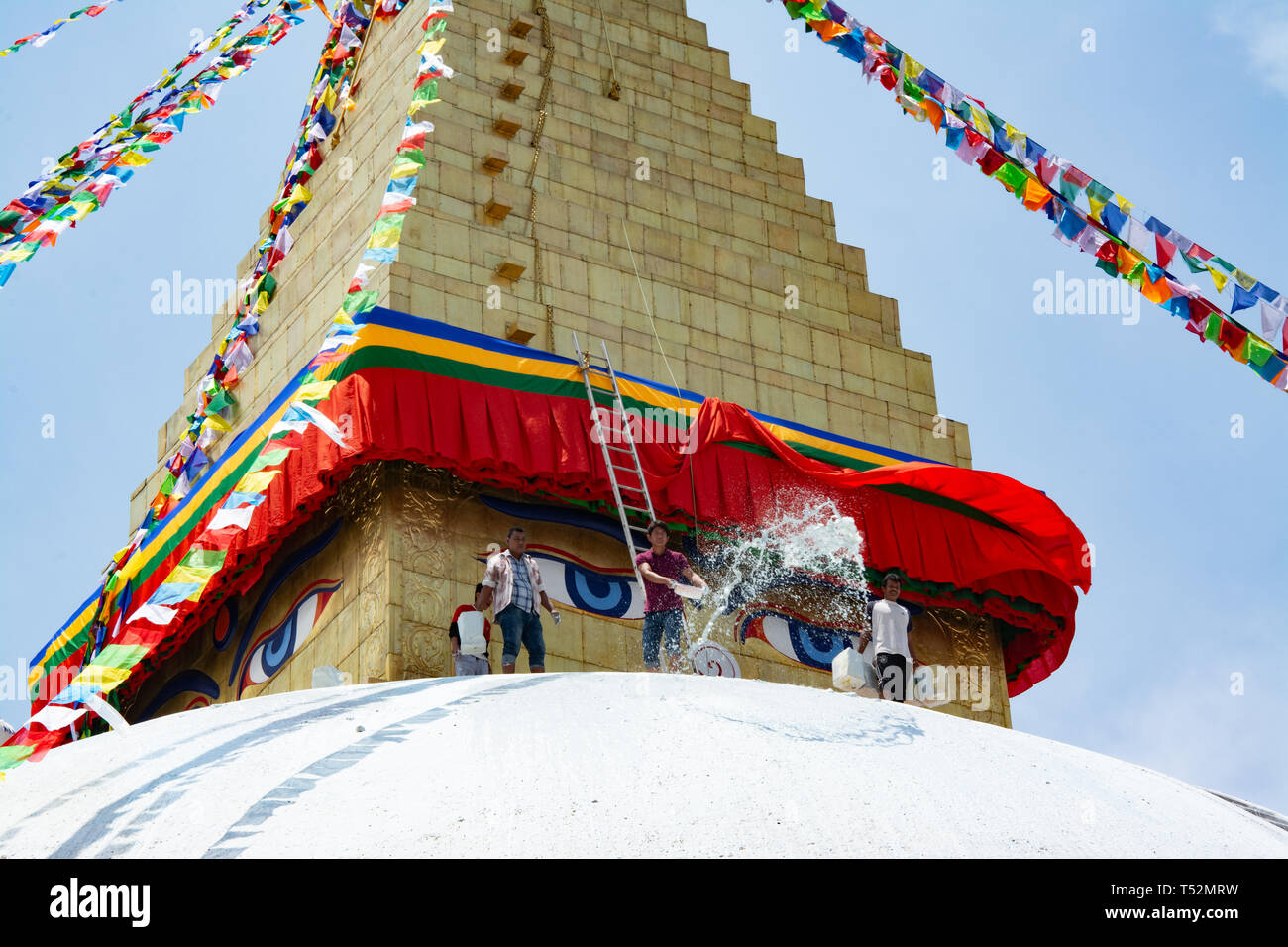 Kathmandu, Nepal - May 10, 2017: Unknown men cleaning the bouddha stupa using water at Bouddhanath Stupa. Stock Photo