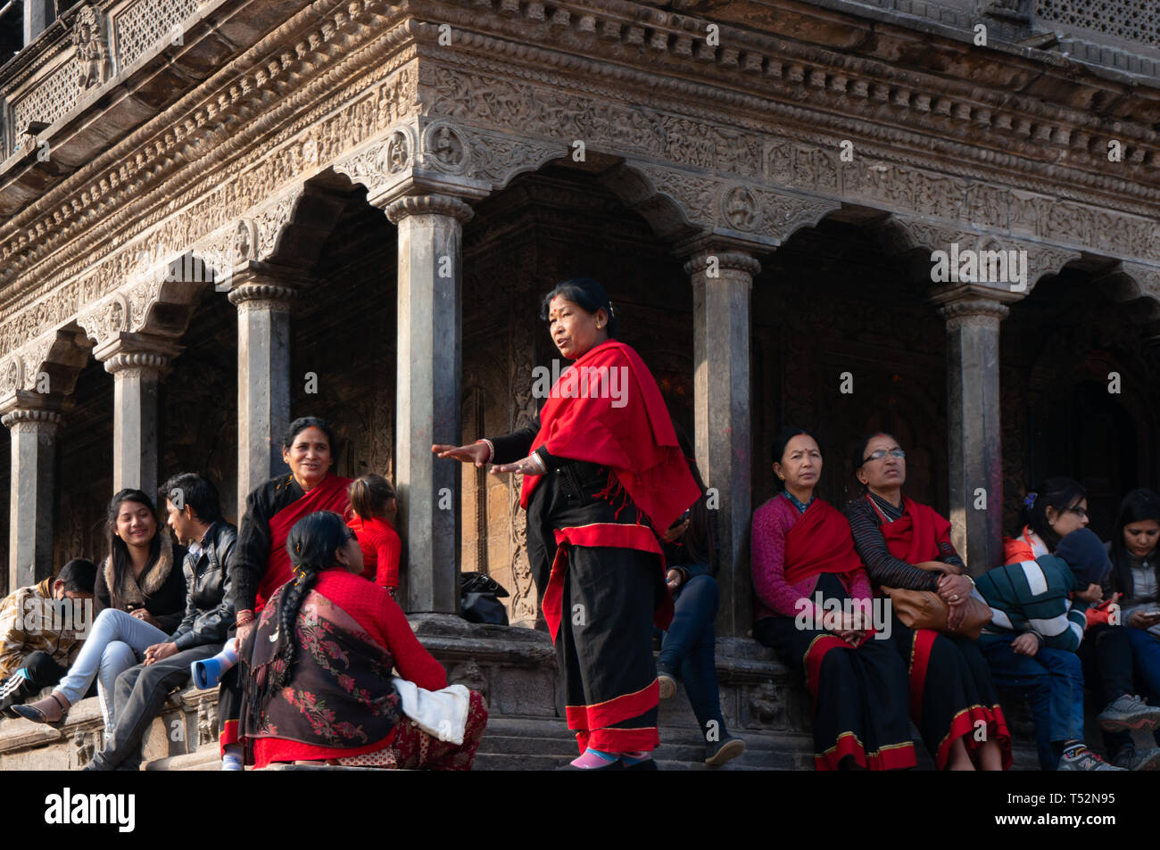 Kathmandu, Nepal - January 15, 2016: Local women in Newari traditional attire engages in conversation. Some people sitting aside talking together. Stock Photo