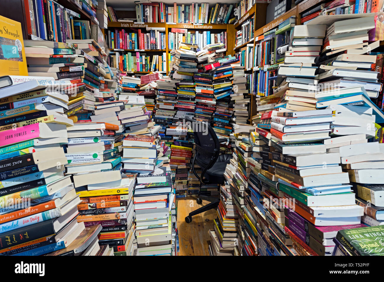 clutter and stacks of books over filling a room for space. Stock Photo