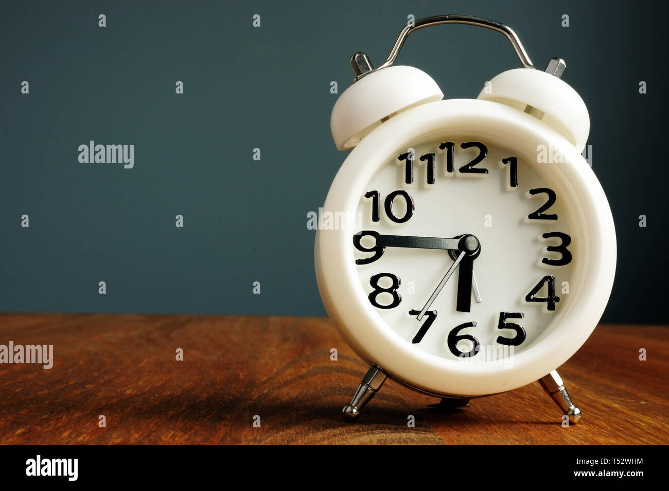 Procrastination and time management concept. Alarm clock on a table. Stock Photo
