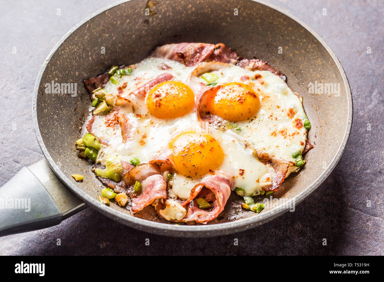 English breakfast fried bacon ham and eggs in ceramic pan Stock Photo
