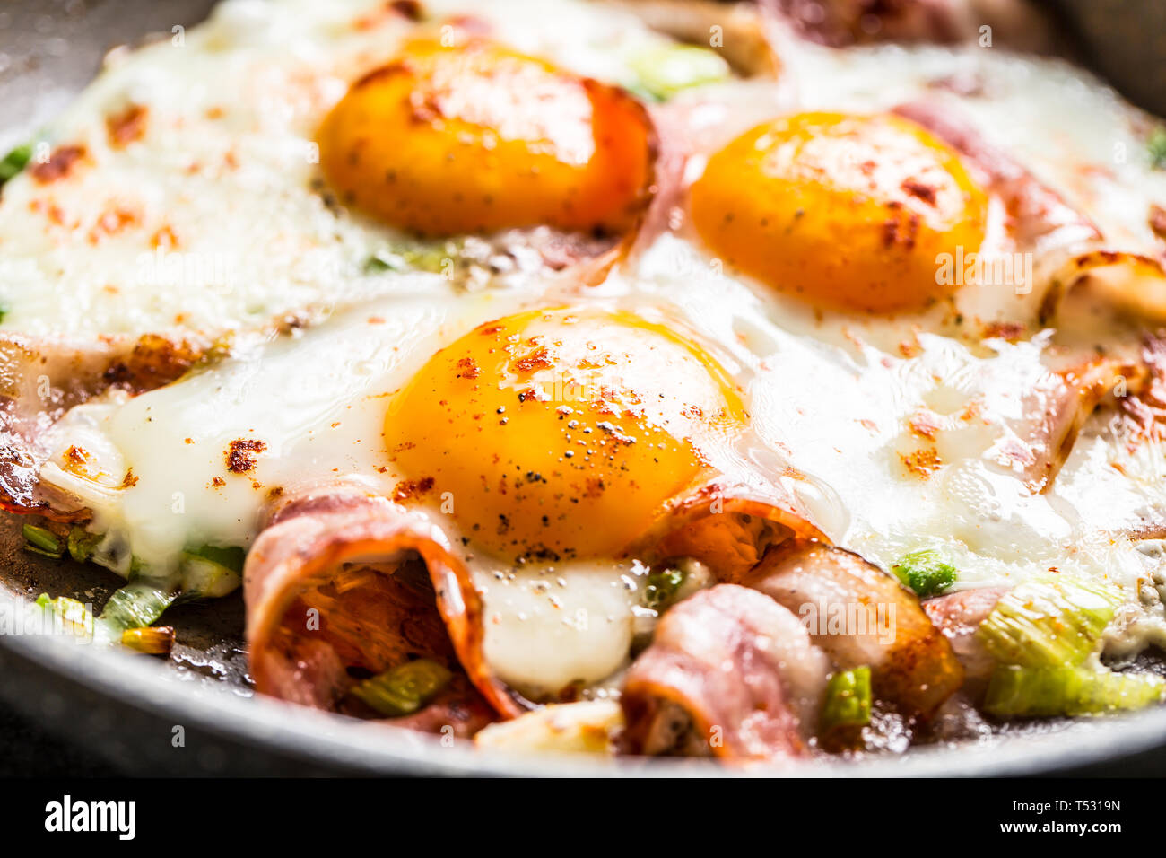 English breakfast fried bacon ham and eggs in ceramic pan Stock Photo