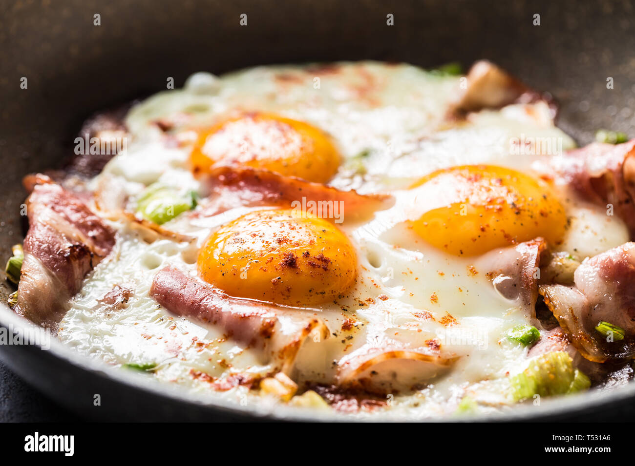 English breakfast fried bacon ham and eggs in ceramic pan Stock Photo