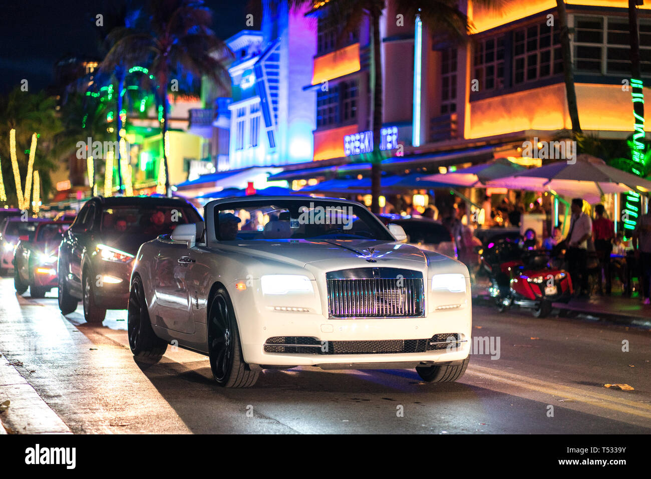 White Rolls Royce Drophead Convertible Car driving down Ocean Drive, South Beach, Miami, FL Stock Photo
