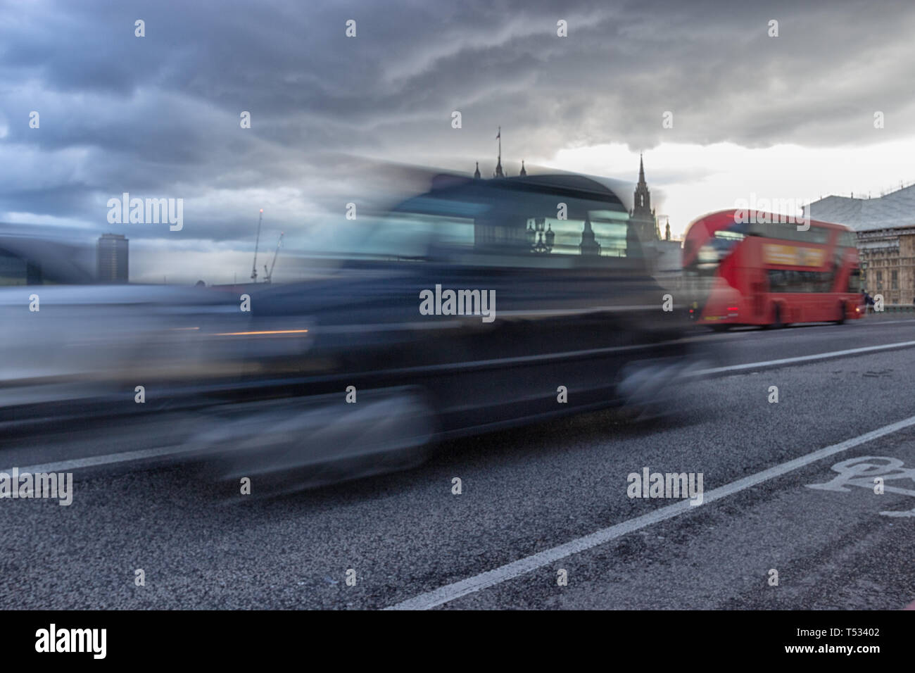 Westminster Bridge, London, England, April 4 2019. A motion blurred iconic London taxi and famous red London bus travelling across the bridge in from Stock Photo