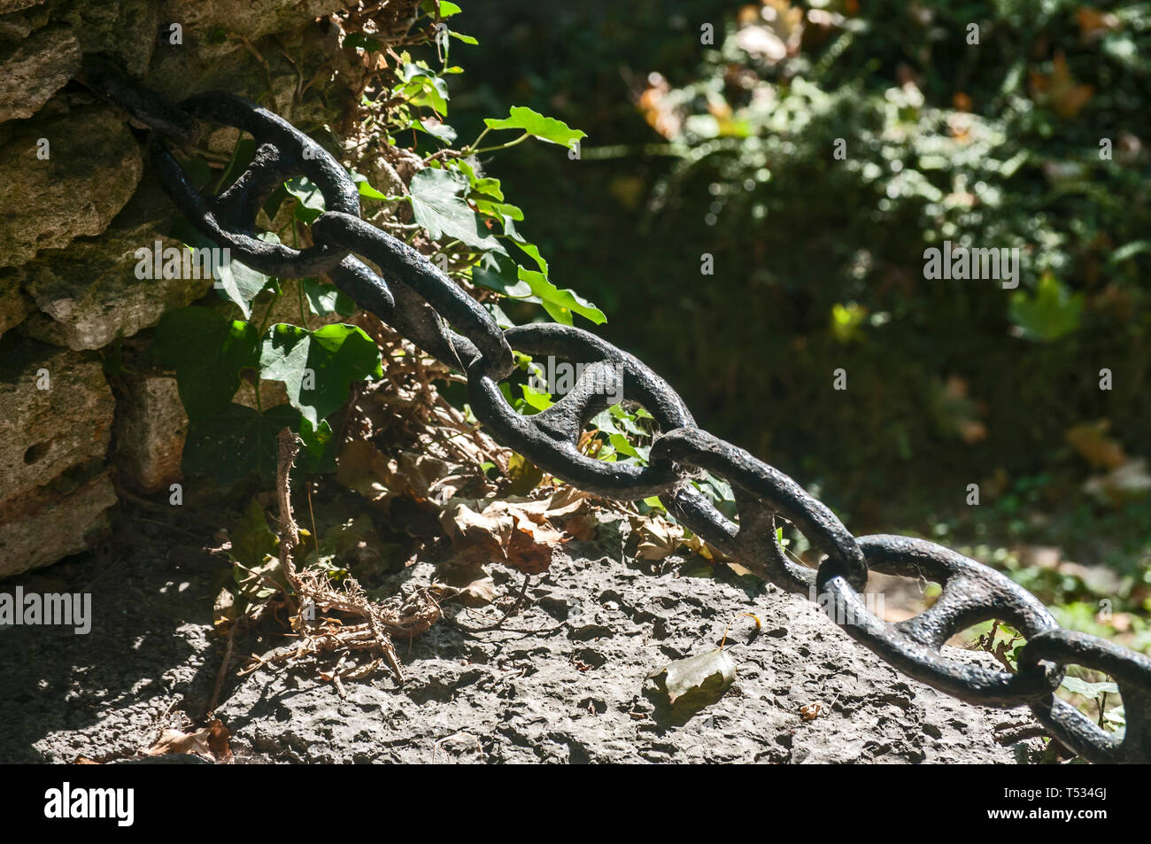 Thick iron black chain links fence closeup as a decorative element in