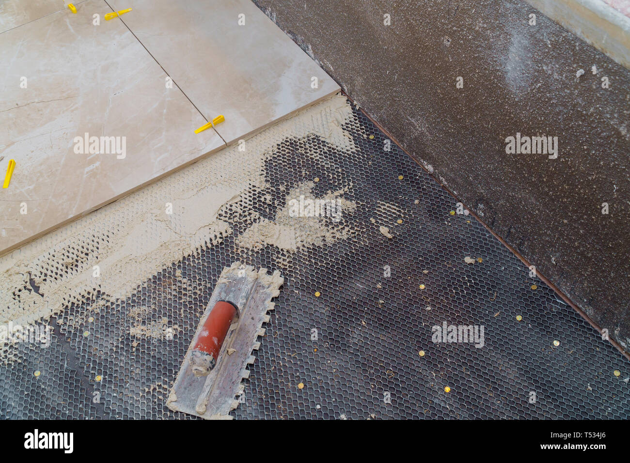 Troweling mortar a concrete floor in preparation for laying floor ceramic tiles Stock Photo Alamy
