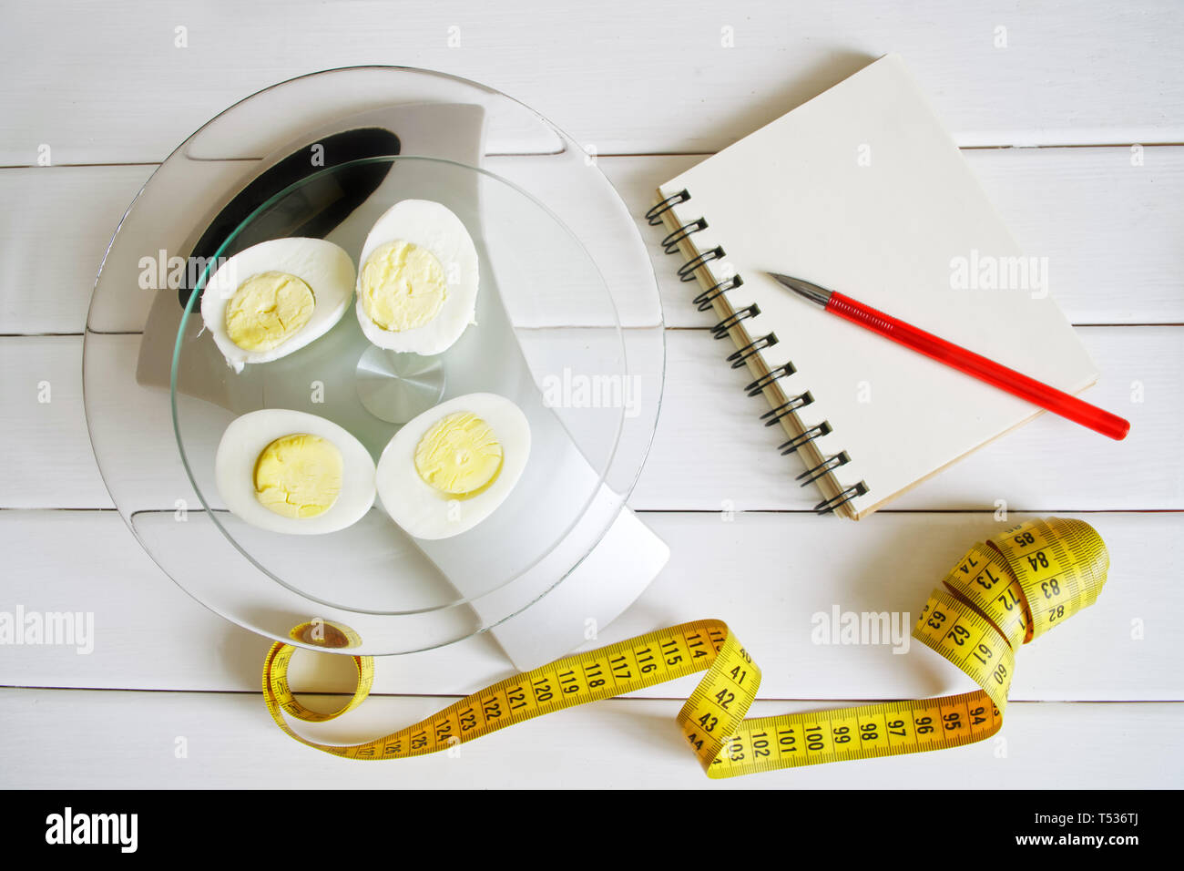 Counting and recording the amount of protein, calories, carbohydrates and fats in food. Chicken egg on the kitchen scales. Slim figure, fitness, weigh Stock Photo