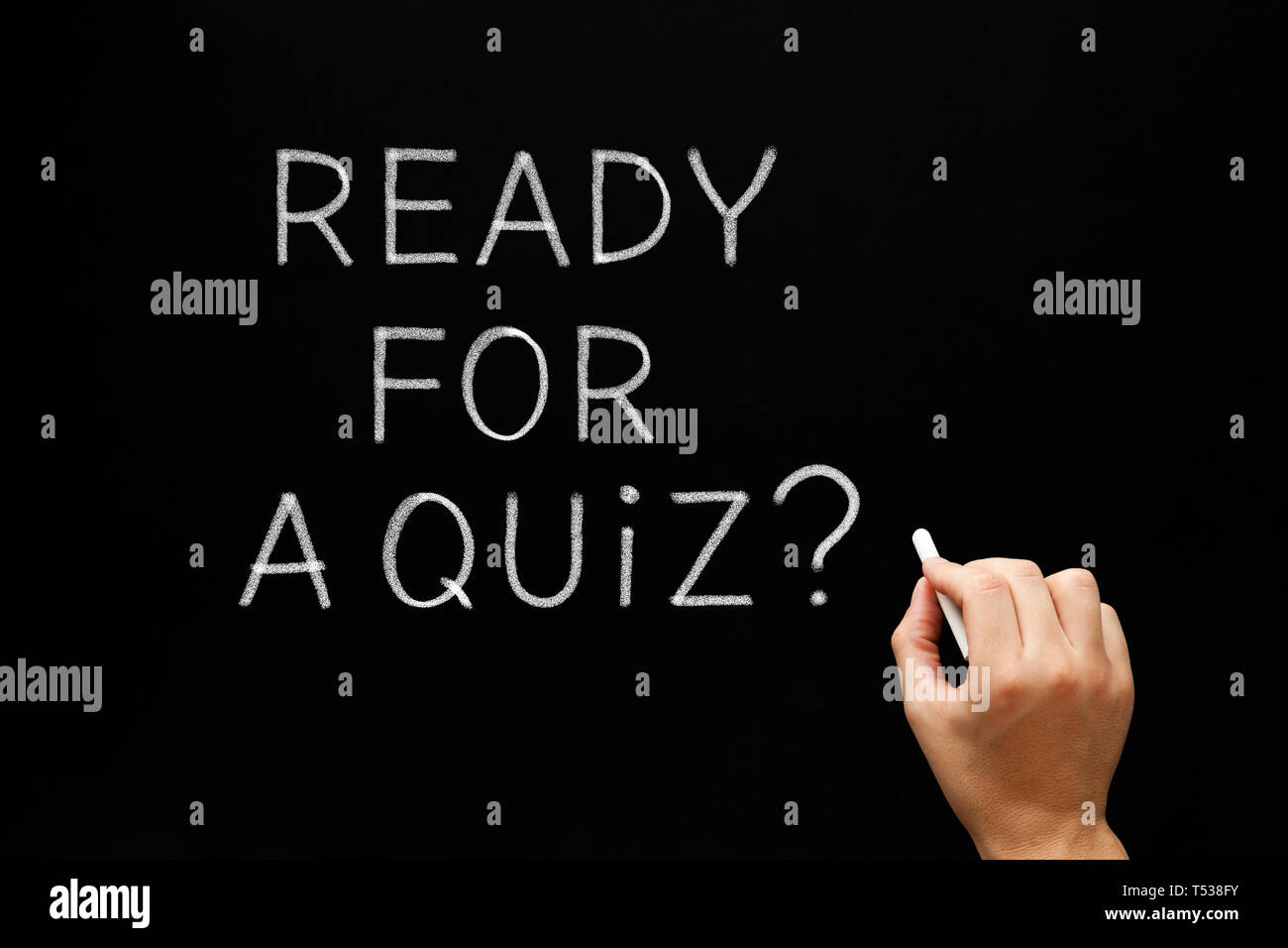 Hand writing the question Ready For A Quiz with white chalk on blackboard. Stock Photo