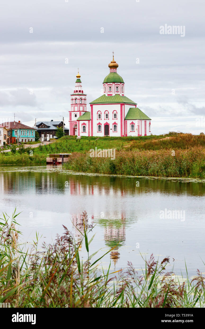 View of Suzdal with Reka Ramenka river, the St Elijah Church and fields with green grasses under a cloudy sky. Suzdalsky District, Golden Ring, Russia Stock Photo