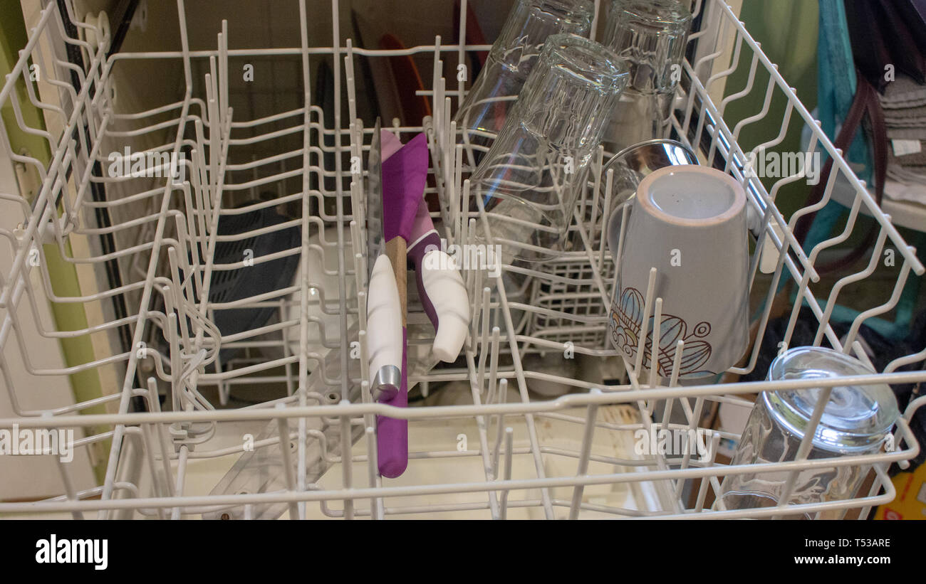 A woman removes dishes after they are finished being washed in a