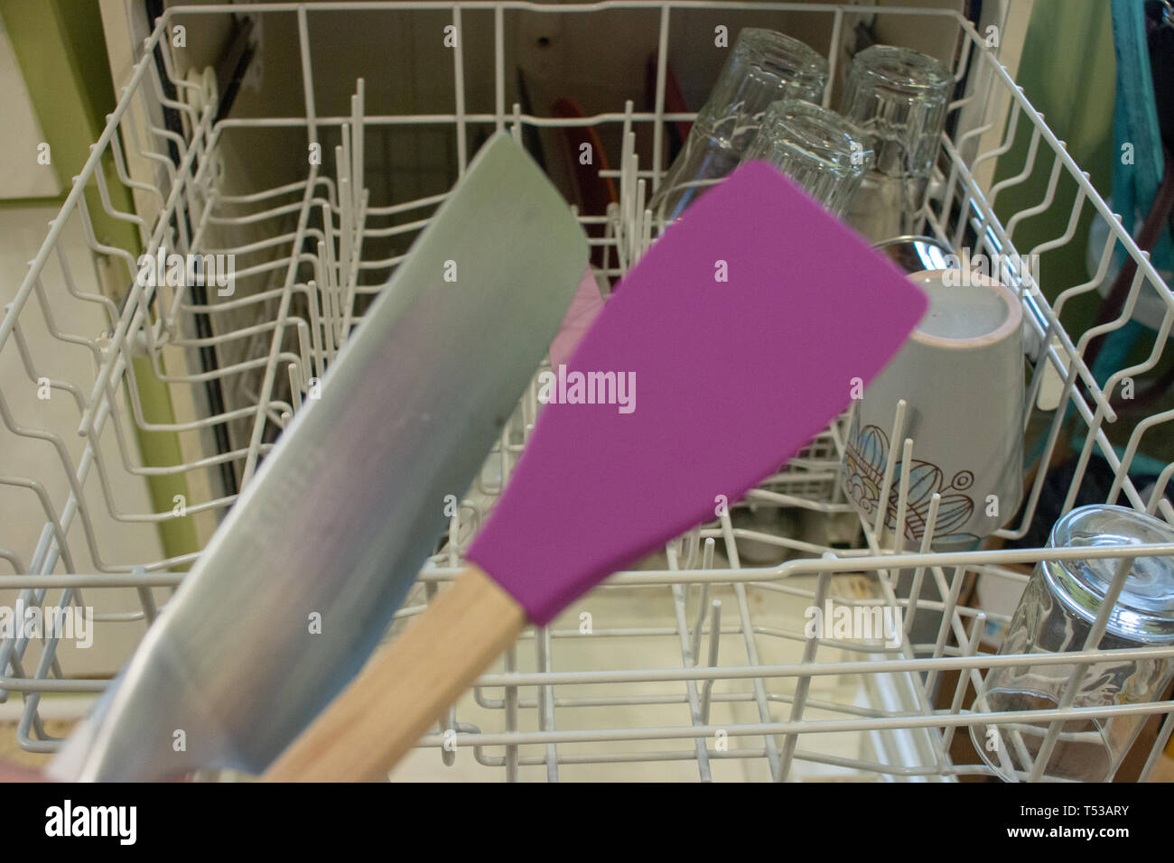 A woman removes dishes after they are finished being washed in a