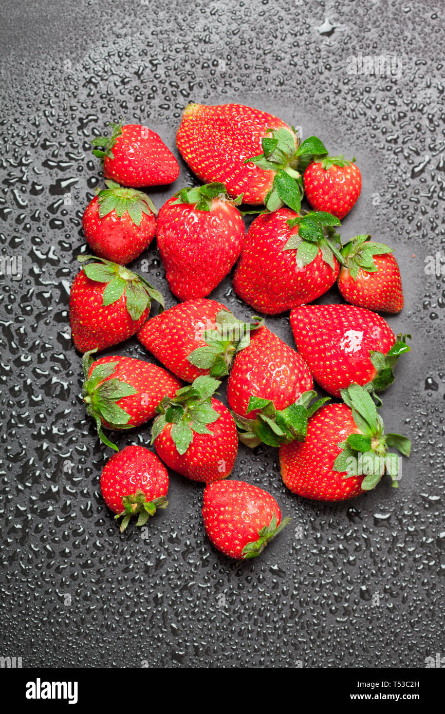 Fresh ripe strawberry with water drops on black background, top view ...