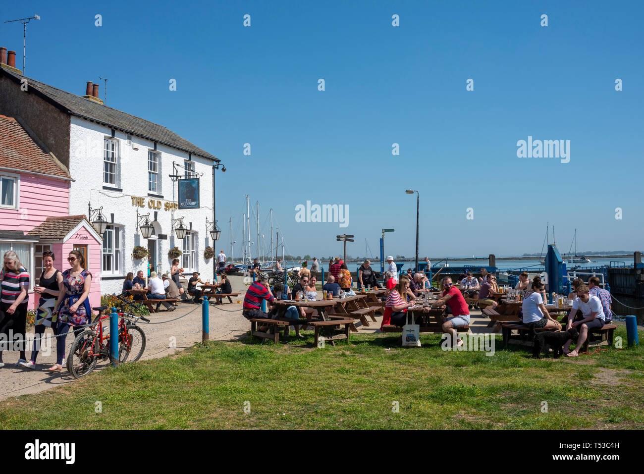Heybridge Basin, Essex, UK. Warm and sunny weather brought people out to visit The Old Ship pub close to the lock to the Chelmer and Blackwater canal Stock Photo