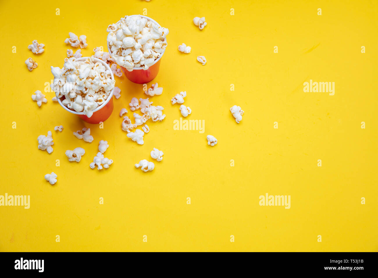 Fresh salty pop corn in two red carton containers, yellow color background, copy space Stock Photo