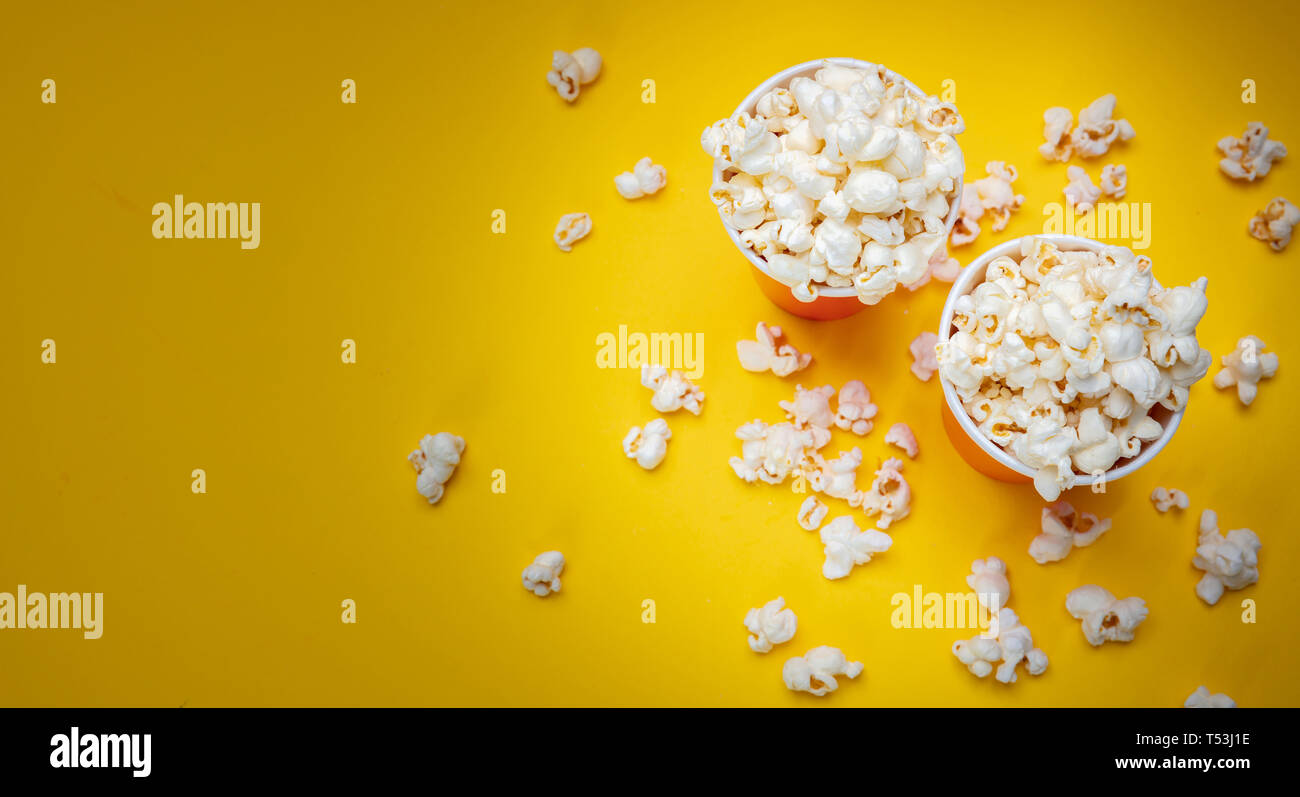 Fresh salty pop corn in two red carton containers, yellow color background, copy space Stock Photo