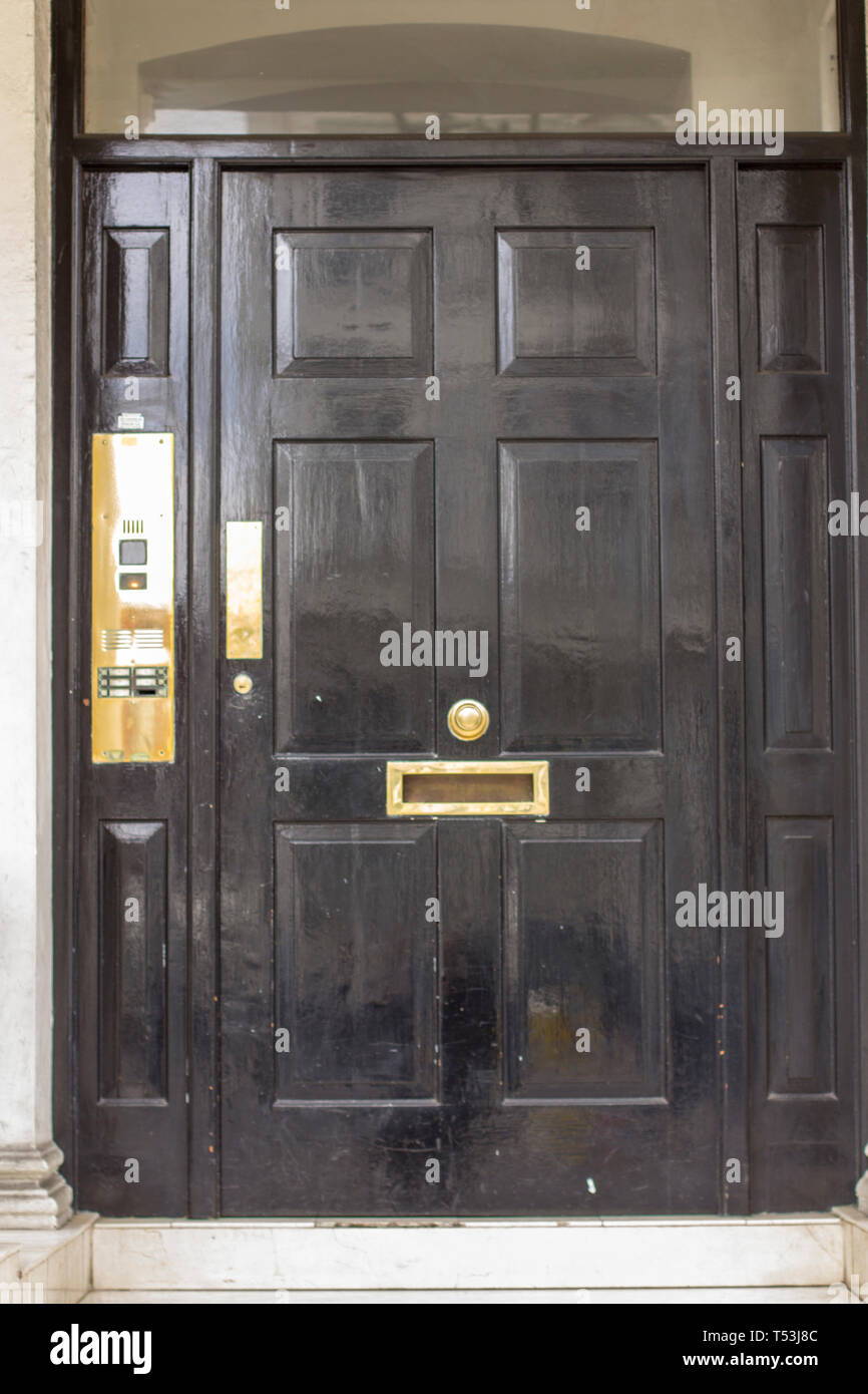 Black Wooden Entrance Door to residential building in London. Typical door in the English style. Stock Photo
