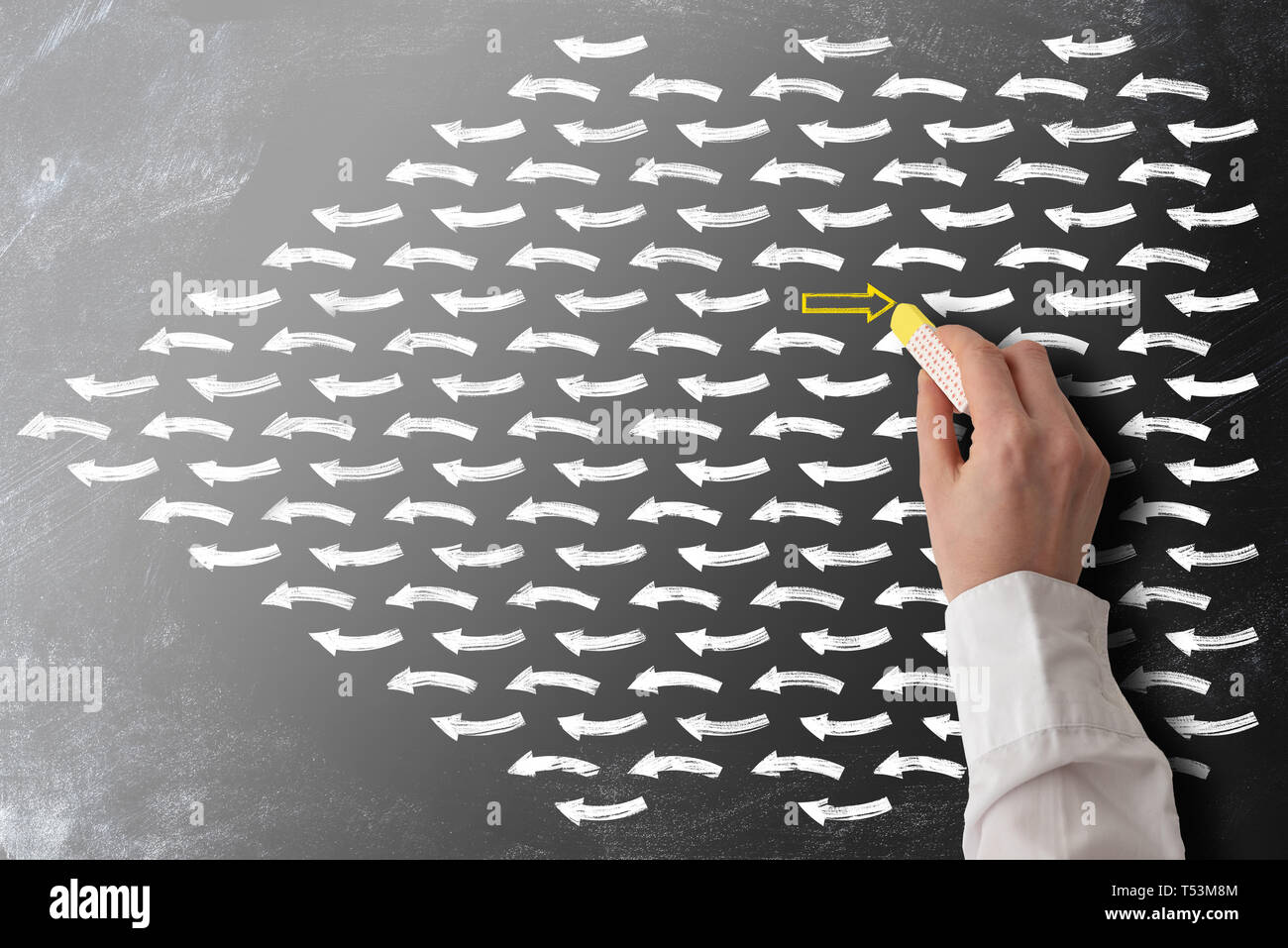 striving against the stream or swim against the tide concept with arrows on blackboard Stock Photo