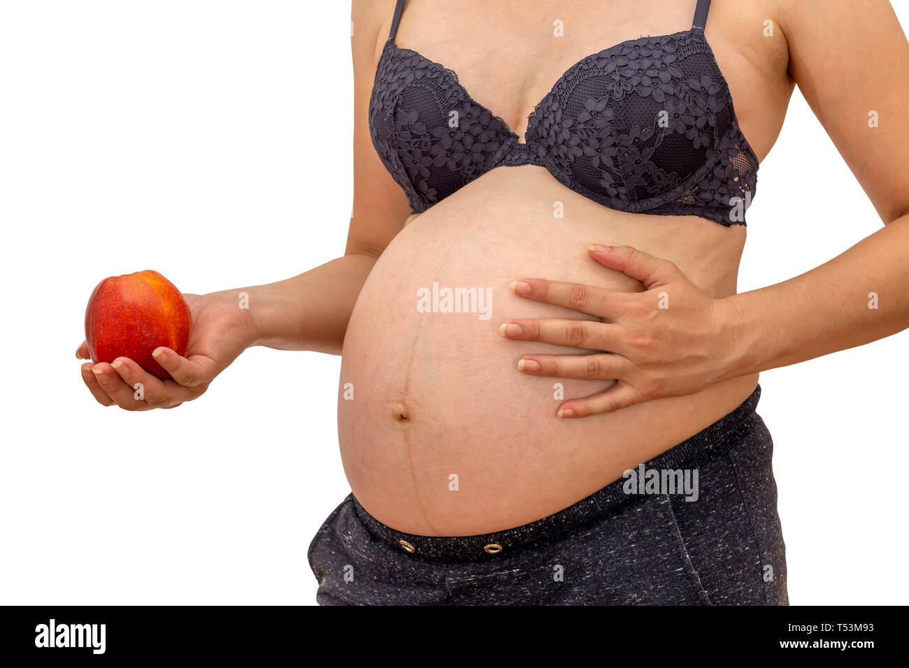 Pregnant woman holding an red apple. Healthy pregnancy and nutrition