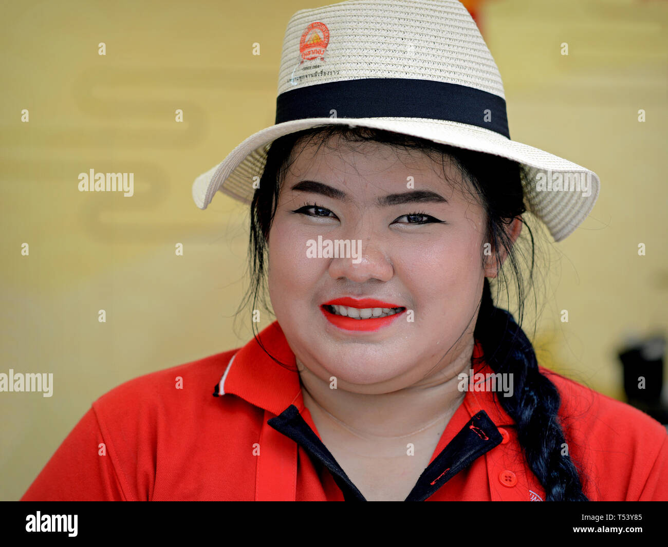 Young, well-built Thai Chinese woman wears a corporate Panama hat and poses for the camera during Chinese New Year celebrations. Stock Photo