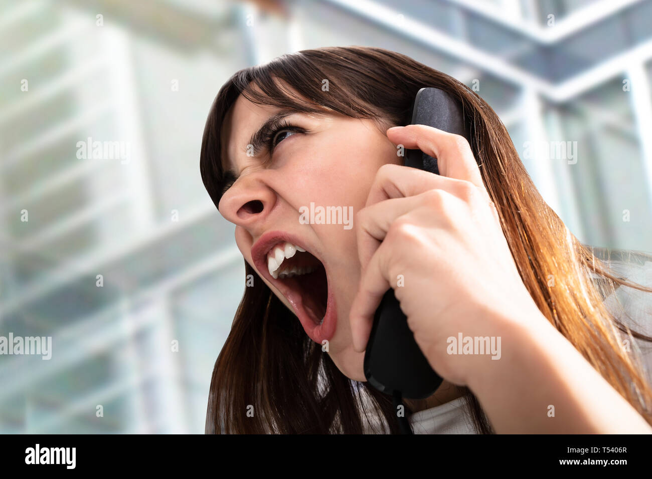 Close-up Of Frustrated Businesswoman Yelling On Phone Stock Photo