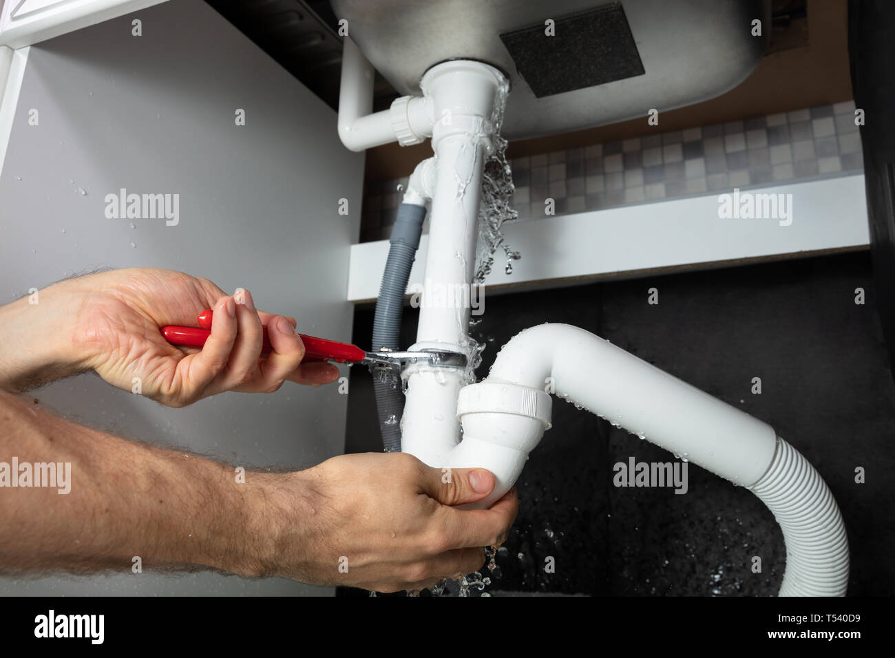 https://c8.alamy.com/comp/T540D9/close-up-of-male-plumber-fixing-white-sink-pipe-with-adjustable-wrench-T540D9.jpg