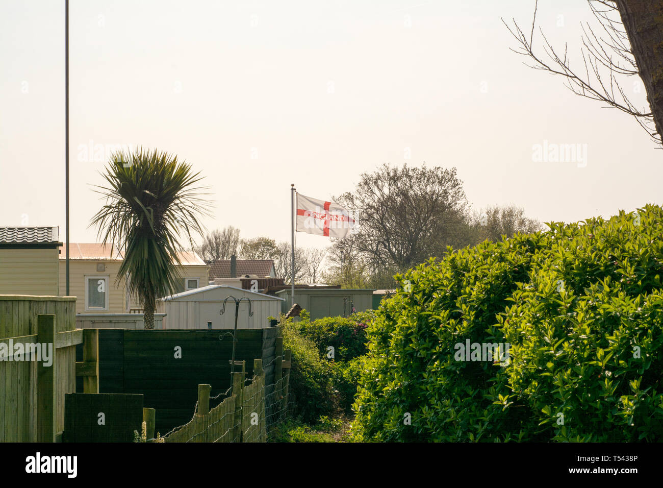 Cloudy skies cover a caravan park in spring time as a England flag flys. Stock Photo