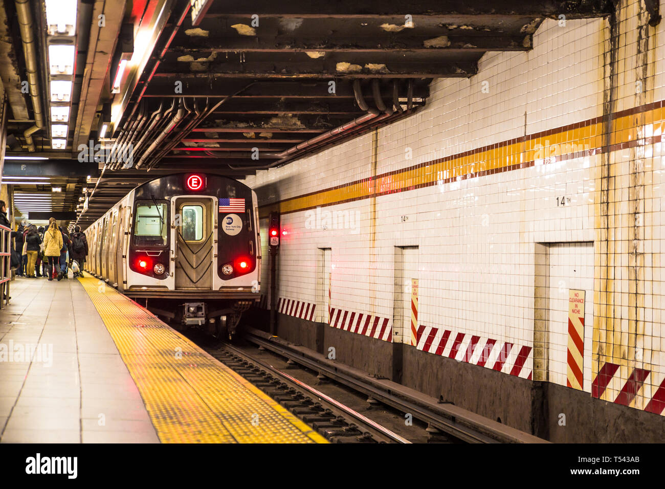 NEW YORK CITY - DECEMBER 3, 2016:  View of inside of underground New York City subway from platform as train approaches and people are visible. Stock Photo