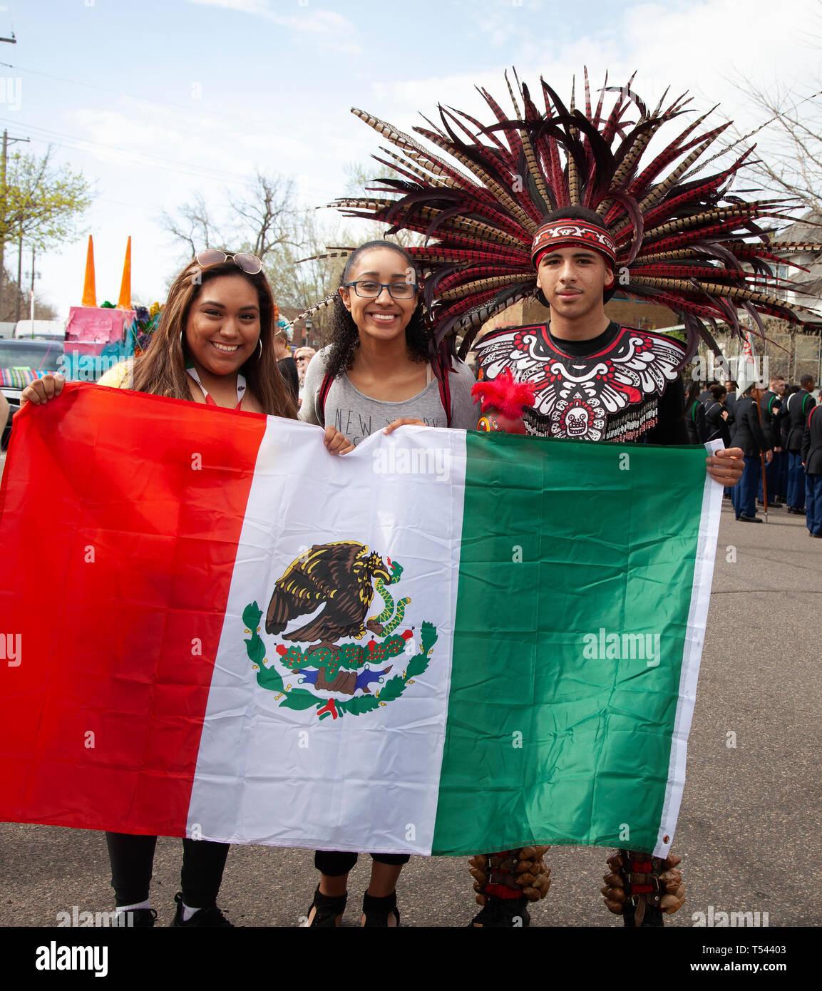 Three people holding mexican flag man in costume parade hires stock