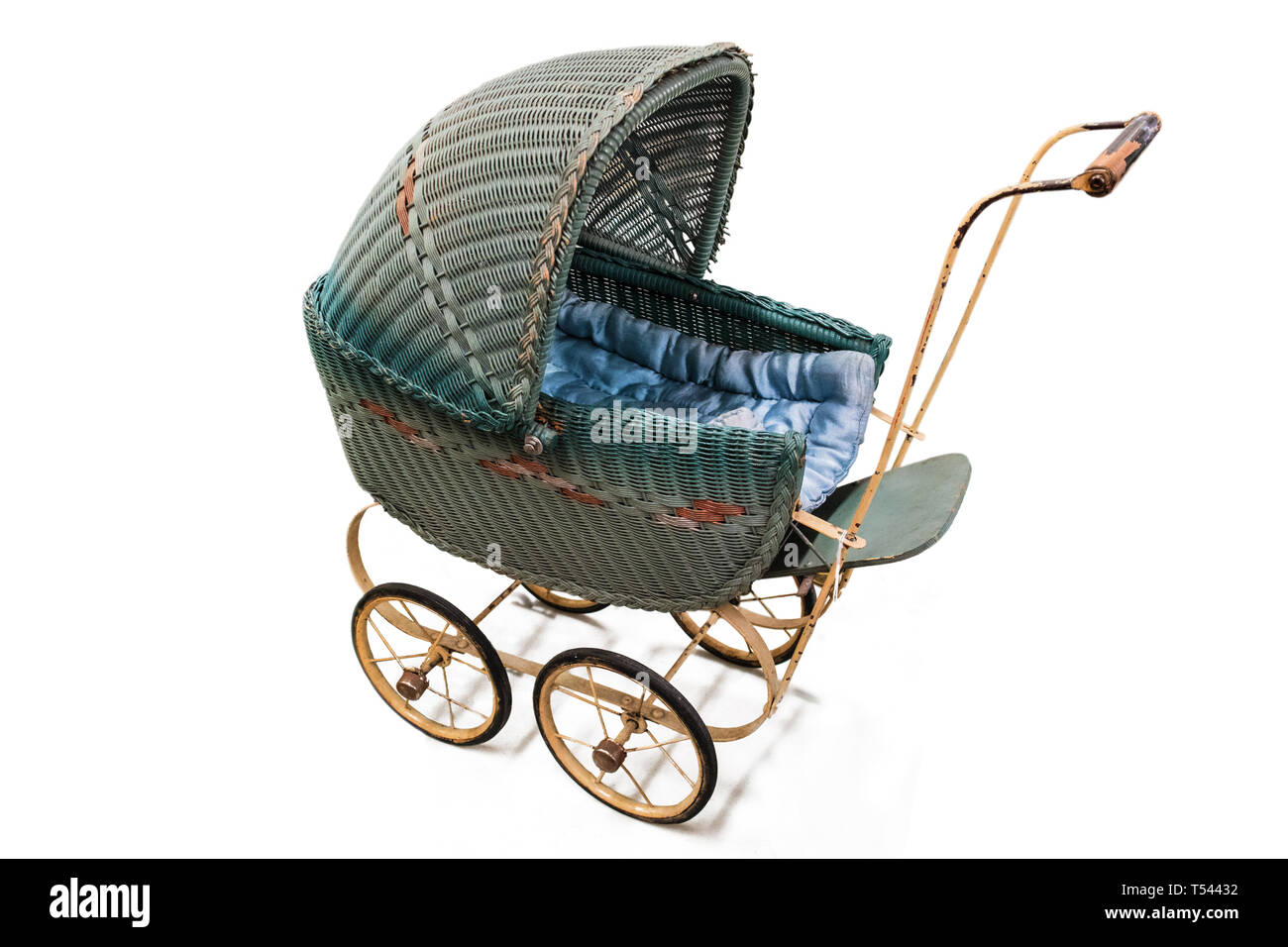 An antique wicker stroller with spoked wheels. Isolated and copy space. Stock Photo