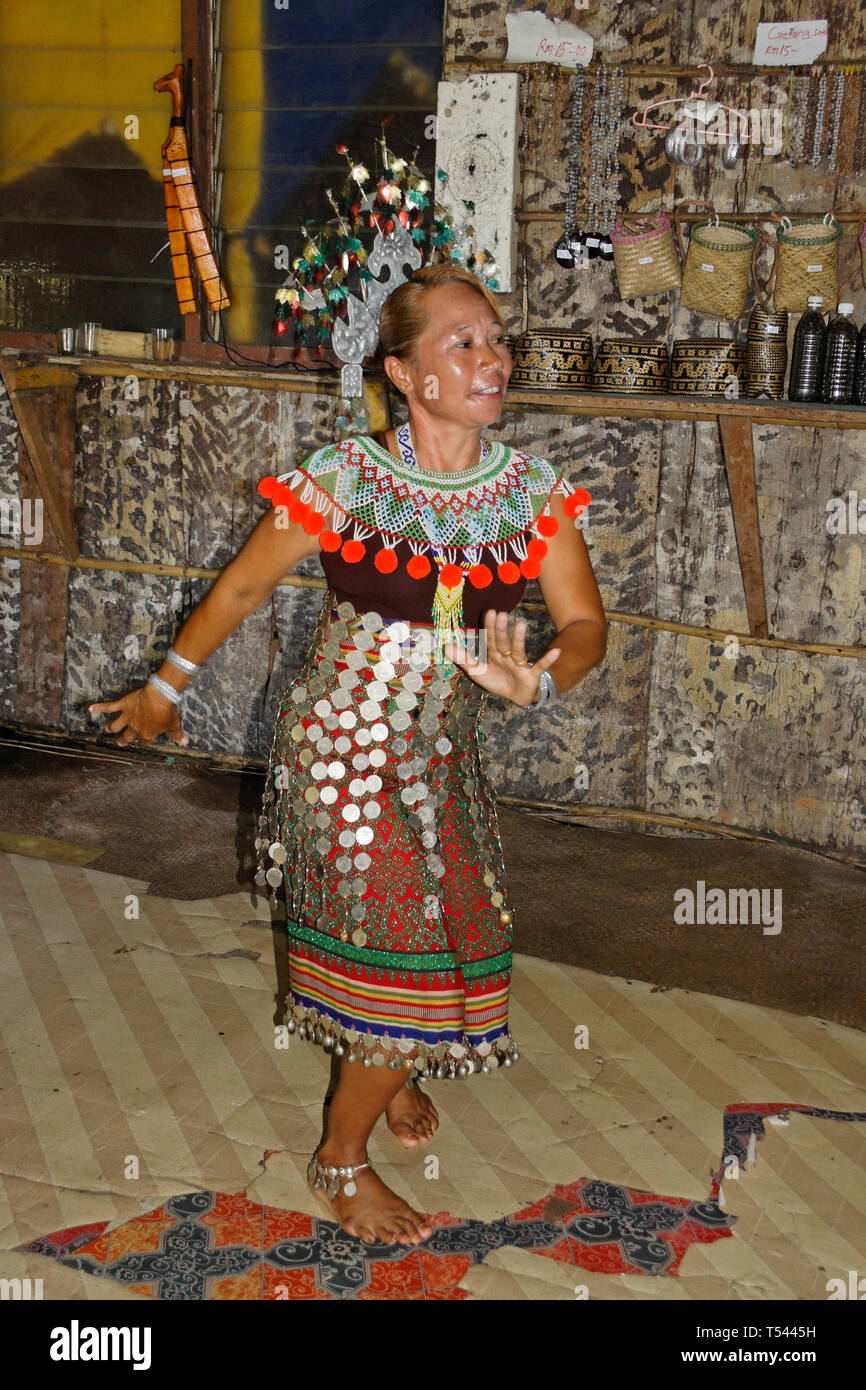 Iban woman dancing while wearing traditional tribal dress, Mengkak Longhouse, Batang Ai, Sarawak (Borneo), Malaysia Stock Photo