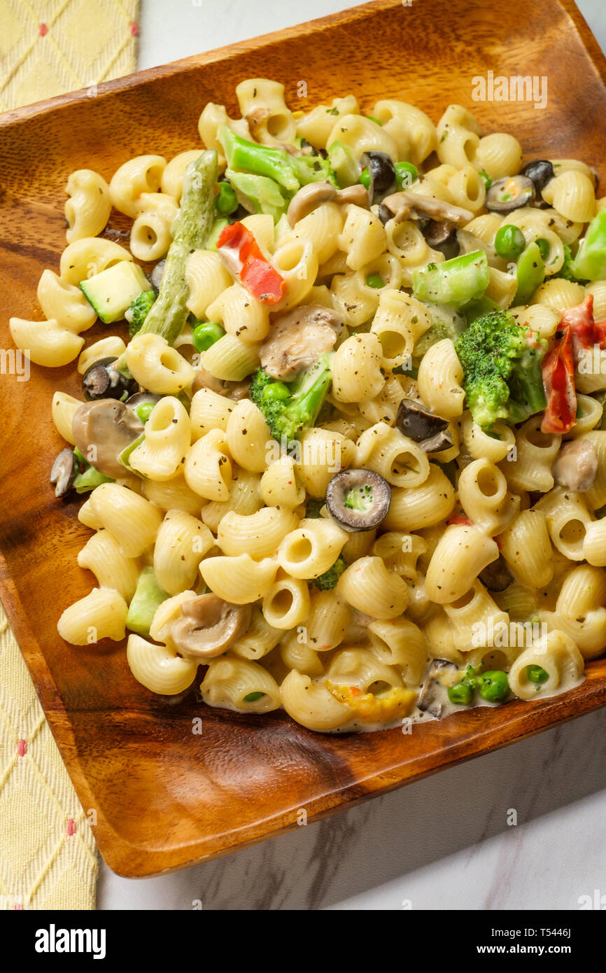 Italian-American cuisine pipette pasta primavera with creamy alfredo sauce  on wooden plate Stock Photo - Alamy