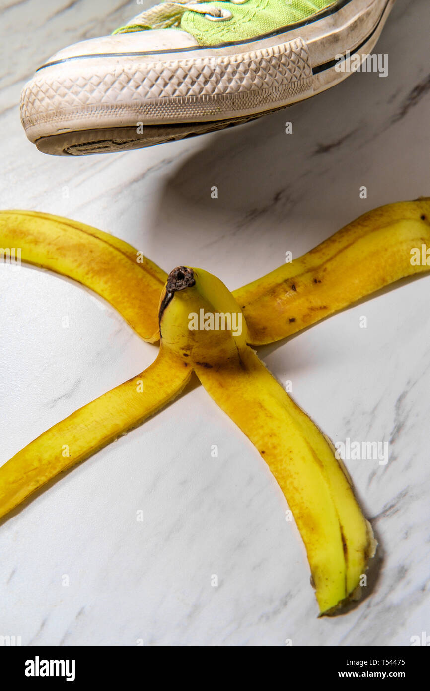 Classic slippery comedy banana peel with sneaker about to step on it Stock Photo Alamy