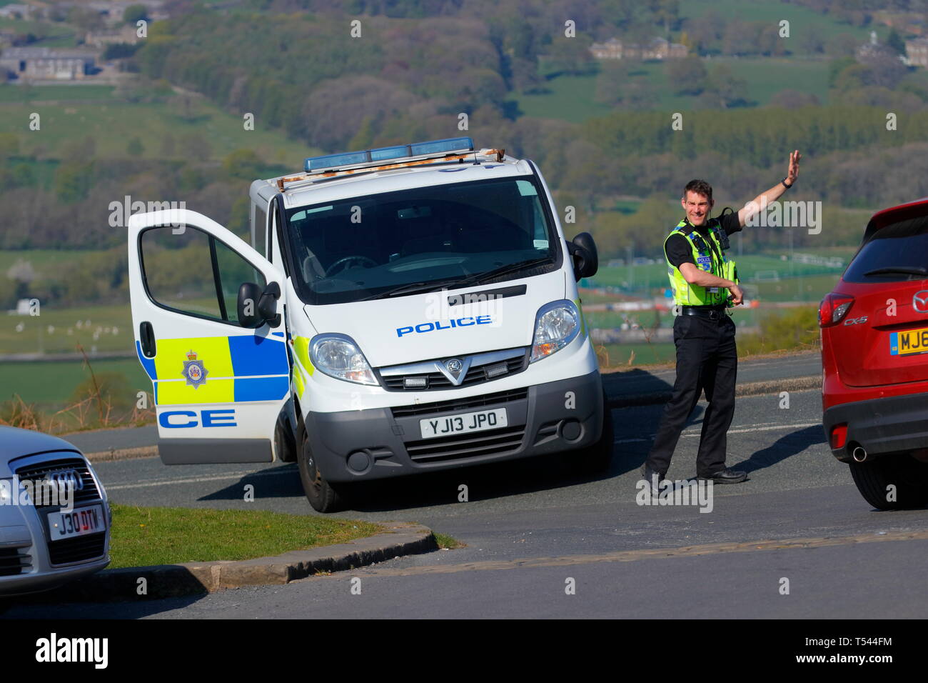 A police officer diverts traffic on Hangingstone Road at the Cow & Calf rocks, after arsonists set fire to Ilkley Moorland Stock Photo