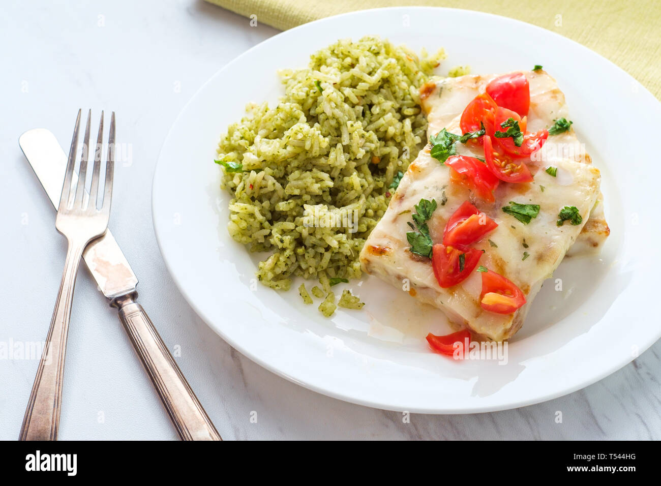 Grilled Alaskan Pollock fish fillets with lemon butter and green rice