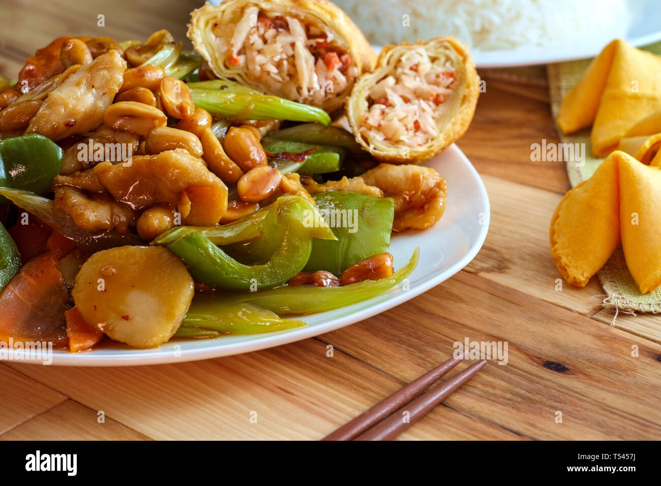 Chinese food spicy Kung Pao Chicken with peanuts and egg roll Stock