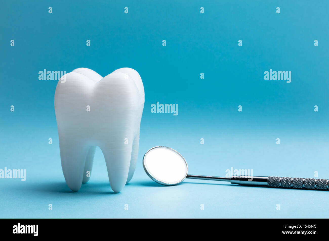 Close-up Of Tooth With Dental Mirror Over Blue Background Stock Photo ...