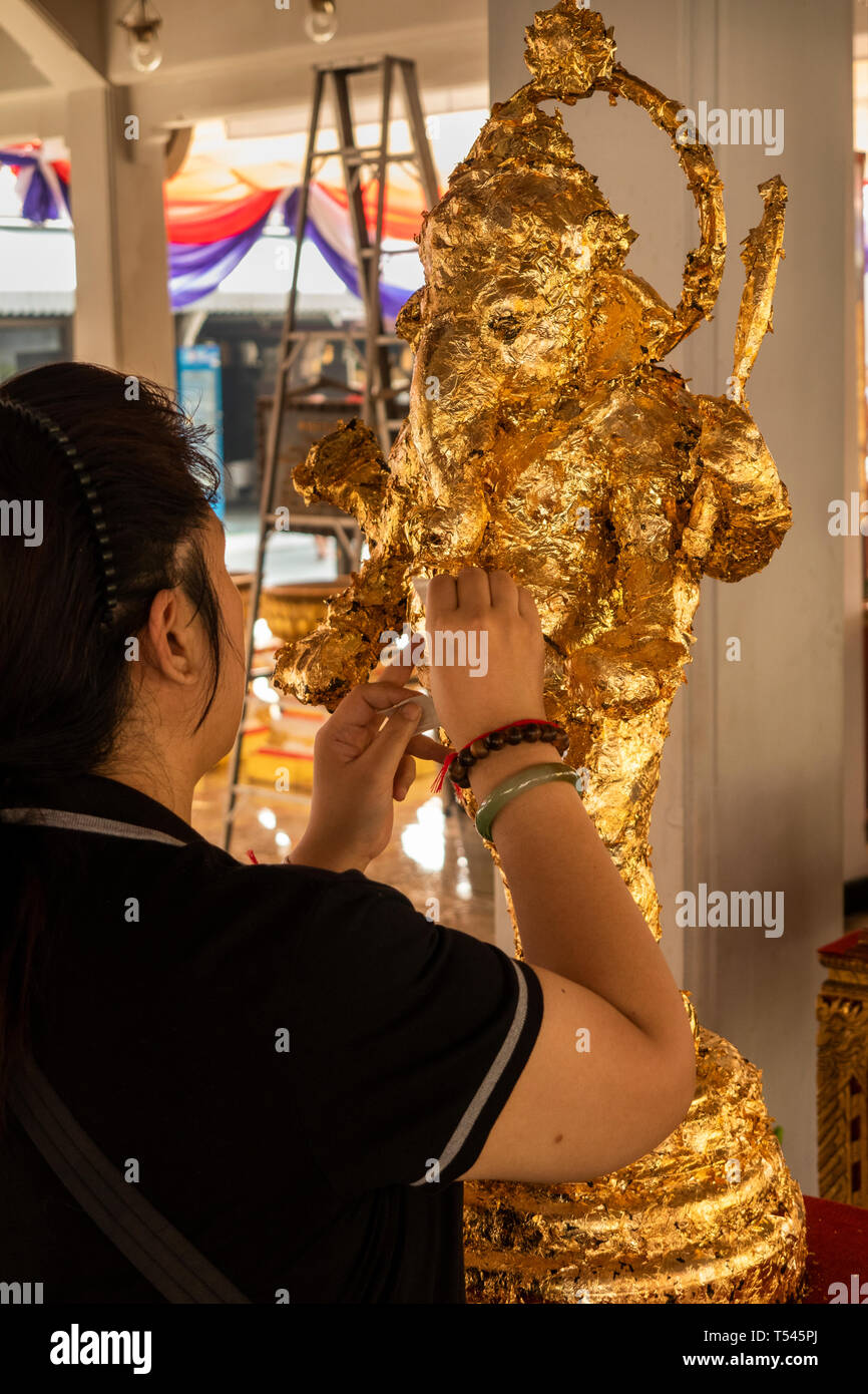 Thailand, Bangkok, Lak Muuang, City Pillar Shrine, worshipper applying gold  leaf to Ganesh Hindu deity figure in main vihara prayer Hall Stock Photo -  Alamy