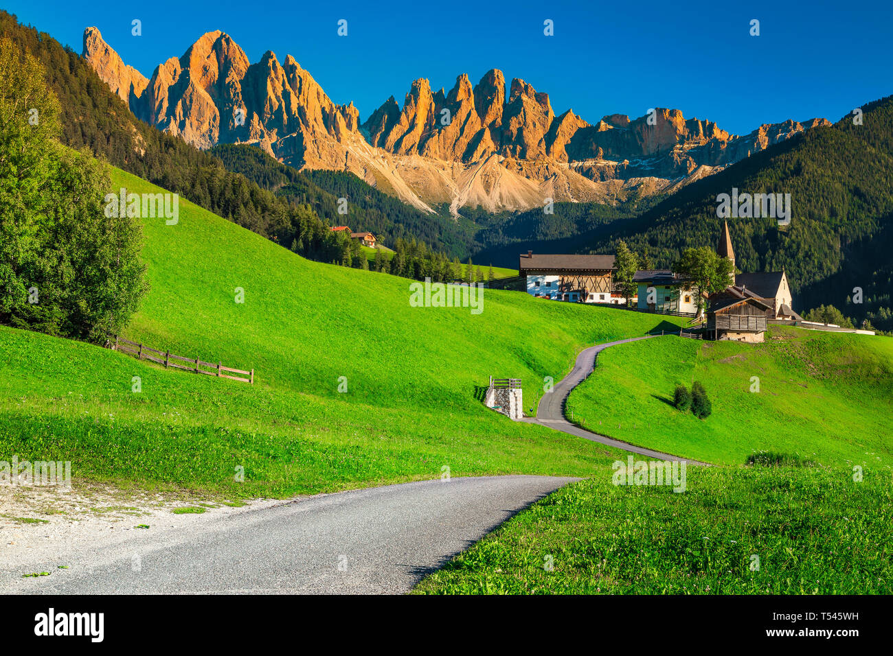 Stunning alpine travel, tourism and hiking destination, Santa Maddalena village with magical Dolomites mountains in background at sunset, Val di Funes Stock Photo